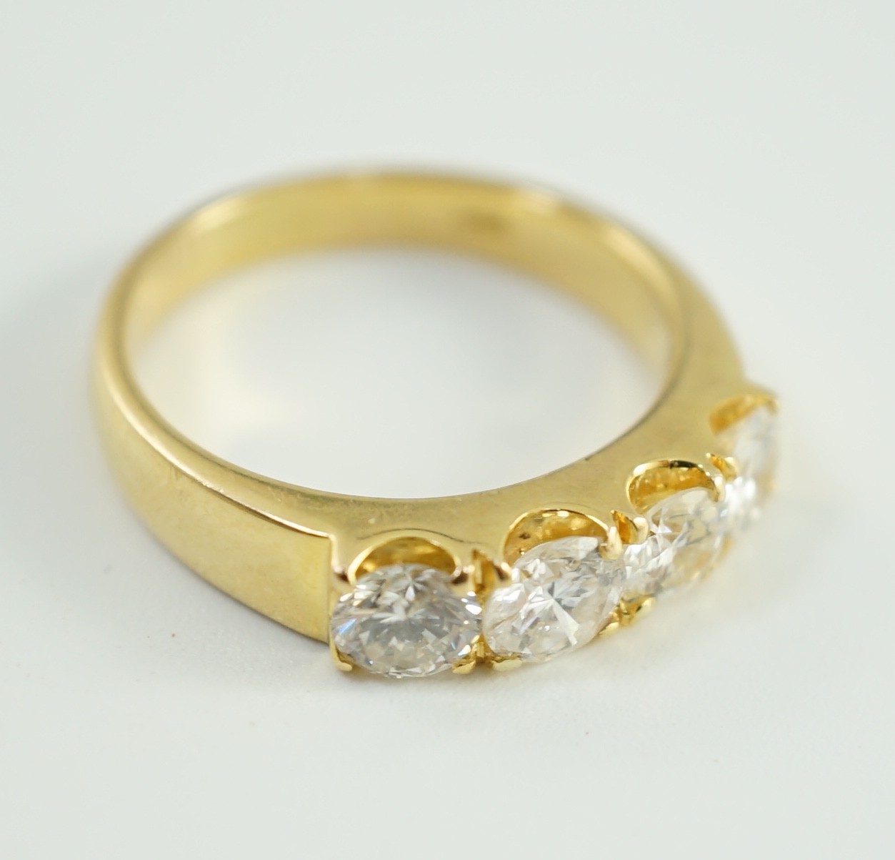 A modern 750 gold and four stone diamond set ring